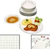 A set of dishes with a meal on one of the plates, and a stack of plates in the background. Podgląd zdjęcia produktu