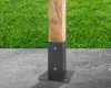 A wooden post is secured to a concrete surface with a metal bracket, with a grassy area in the background. Náhled obrázku produktu