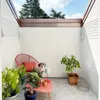 A small outdoor patio area with a chair, plants, and a small table. Produktbild-Vorschau