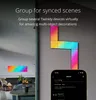 A smartphone displaying a Twinkly app interface is shown in the foreground, with a wall-mounted LED light display in the background. Náhľad obrázku produktu