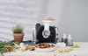 A kitchen appliance is shown with fresh vegetables and a bowl of food. Anteprima dell’immagine prodotto