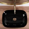 A black basin with a gold faucet on a wooden countertop. Anteprima dell’immagine prodotto