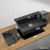A black kitchen sink and a separate black basin are shown on a wooden countertop with dimensions indicated by numbers and lines. Produktbild-Vorschau
