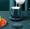 A dark teal mug with the word 'Lucky' on it is being filled with milk, sitting on a matching coaster. A small dish of strawberries is in the foreground. Produktbild-Vorschau