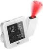 A white Braun projection alarm clock is shown against a white background. The clock displays the time 12:15 and an alarm time of 7:00. A red laser projection beam displays the time 12:15 on a surface above the clock. Produktbild-Vorschau