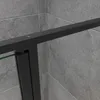 A close-up view of a black framed shower door with glass panels, set against a grey tiled wall. Produktbild-Vorschau