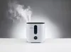 A white humidifier emitting mist, placed on a white surface against a gradient gray background. Produktbild-Vorschau