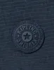 A close-up of a dark blue Kipling logo on a dark blue textured background. Produktbild-Vorschau