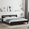 A black wooden bed frame with a headboard and a blue blanket on the mattress, set in a bedroom with white walls and grey curtains. Náhled obrázku produktu