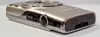 A close-up, angled view of the side and bottom of a silver Canon digital camera. Produktbild-Vorschau