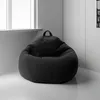 A dark gray bean bag chair sits in the corner of a room, next to a window. Voir les images du produit