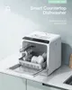 A white countertop dishwasher with its door open, showing the interior racks and dishes, placed on a kitchen counter. Produktbild-Vorschau
