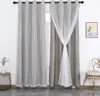 A pair of grey curtains with white sheer overlay, decorated with small stars, is shown hanging on a window rod. A small side table with a vase of flowers is to the left, and a decorative chair is to the right. Anteprima dell’immagine prodotto