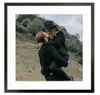 A couple embracing outdoors with a hilly, green background. Náhľad obrázku produktu
