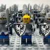 A close-up view of several LEGO knights with shields and swords, with one knight in the foreground having a yellow head. Náhled obrázku produktu