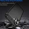 A black smartphone case with carbon fiber accents is shown at an angle, resting on a dark, rocky surface. The background is dark and out of focus. Náhled obrázku produktu