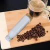 A coffee filter and coffee beans are arranged on a wooden cutting board next to a cup of coffee. Anteprima dell’immagine prodotto