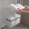 Weißer hängender Draht-Kleiderschrank-Organizer mit zwei Ablagen, die gestapelte weiße und graue T-Shirts halten, eine Hand legt ein Hemd auf die obere Ablage Anteprima dell’immagine prodotto
