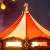 A close-up view of the top of a carousel with a golden horse figurine. Produktbild-Vorschau