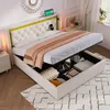 A bed with its storage compartment open, showing stored items. The bed is in a bedroom setting with a nightstand and window visible. Produktbild-Vorschau