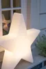 A large, illuminated star-shaped lamp is placed on a stone surface in front of a window. Produktbild-Vorschau