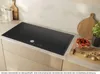 A modern kitchen countertop with a black induction hob, wooden cutting boards, and ingredients. Anteprima dell’immagine prodotto