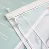 A close-up view of a transparent curtain with white strings and clips, layered over a patterned background with text. Produktbild-Vorschau