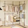 A corner of a room with a telescoping clothes rack filled with clothing and accessories. Náhľad obrázku produktu