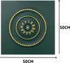A square panel with a decorative circular motif in the center, featuring a floral design with gold accents on a dark green background. Dimensions are indicated by text. Produktbild-Vorschau