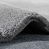A close-up view of a gray, high-pile rug, showing its texture and the underside. Produktbild-Vorschau