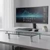 A glass monitor stand is placed on a desk in front of a computer monitor. Produktbild-Vorschau
