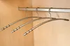 Several metal hangers hanging on a rail inside a closet. Produktbild-Vorschau