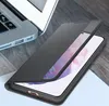 A black phone case is shown on a wooden surface next to a laptop. Voir les images du produit