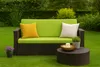 A garden bench with cushions and a coffee table on a grassy lawn. Anteprima dell’immagine prodotto