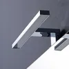 A close-up of a modern LED wall light fixture with a chrome finish, mounted on a gray wall. Anteprima dell’immagine prodotto