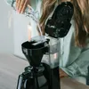 A person is pouring water into a coffee maker. Anteprima dell’immagine prodotto