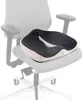 A black and white orthopedic seat cushion is placed on a chair. Náhľad obrázku produktu