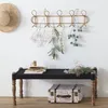 A hallway or entryway scene with a wall-mounted coat rack, a bench, and decorative items. Náhled obrázku produktu