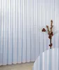 A white transparent curtain with a floral arrangement in a vase. Produktbild-Vorschau