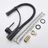 A black kitchen faucet and its accessories are laid out on a white background. Produktbild-Vorschau