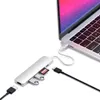 A silver USB-C hub is connected to a laptop, with various ports and inserted memory cards visible. Voir les images du produit