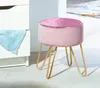 A pink velvet stool with gold legs sits next to a white dresser. Produktbild-Vorschau