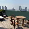 A rooftop patio with furniture and a view of a city skyline. Produktbild-Vorschau