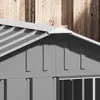 A close-up view of the roof and upper wall of a gray metal dog house, with a wooden fence in the background. Podgląd zdjęcia produktu