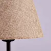 Close-up of a lampshade made of textured fabric, with a black lamp base visible at the bottom. Produktbild-Vorschau