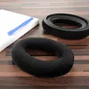 Two black ear pads and a blue tool are placed on a wooden surface. Produktbild-Vorschau