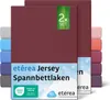 A stack of folded jersey fitted sheets in various colors, with the front sheet prominently displaying branding and product information.