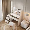 A white vanity table with a lighted mirror, drawers, and shelves, set up in a room with curtains and a nightstand. Produktbild-Vorschau