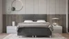 A modern bedroom with a bed, nightstands, and wall decor. Produktbild-Vorschau