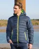A man wearing a padded jacket stands outdoors near a body of water. Produktbild-Vorschau